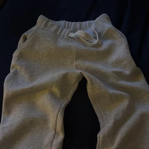 Grå mjukisbyxor från Russedress  - Snygga ljusgrå mjukisbyxor i storlek XXS från Russemerch. Byxorna har resår i midjan och vit snörning framtill. Mjukt material och klassisk passform. Inga defekter o skriv för fler frågor