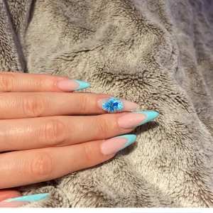 Nageldesign med blå spets och blomma - Handgjorda naglar med färgad tip och 3D blomma, färg kan önskas. naglarna görs efter beställning så skickas inom en dag drygt.🫐