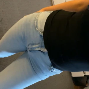 Ljusblå bootcut jeans  - Säljer ett par ljusblå jeans från Gina tricot med klassisk femficksdesign och bootcut ben. Jeansen har normal midja, gylf med dragkedja och knapp samt kontrastsömmar. Perfekta för en avslappnad och stilren look.