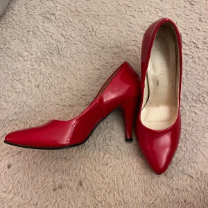 Röda lackpumps med spetsig tå - Snygga röda pumps i glansigt lackmaterial med spetsig tå