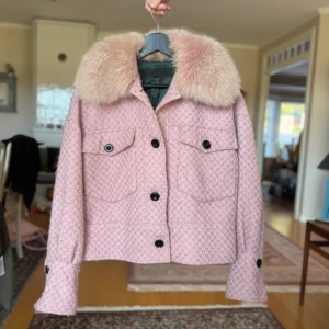 Meotine jacka - Säljer en superfin rosa jacka från Meotine med stor fluffig pälskrage i räv. Jackan har ett strukturerat tyg, stora svarta knappar och två fickor framtill. Materialmix av ull och polyester, fodrad och perfekt för höst och vinter. Snygg och trendig modell!
