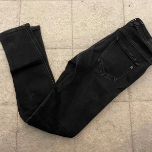 Svarta Replay Hyperflex jeans  - Säljer ett par svarta Replay Hyperflex jeans. Jeansen har klassisk femficksdesign, diskret Replay-logga på bakfickan och stretchigt material som sitter tajt och bekvämt. Perfekta för dig som gillar en stilren och modern look.
