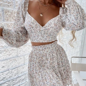 Vit blommigt set - Fint sommar set  med blommor och volanger. Sitter inte bra på mig och toppen är förliten för mig