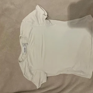 Basic vit tröja från Weekday XS - En basic vit t-shirt från Weekday i storlek XS (rätt så liten). T-shirten har rund halsringning och korta ärmar. Tillverkad i mjuk bomull, perfekt för en clean och enkel stil.
