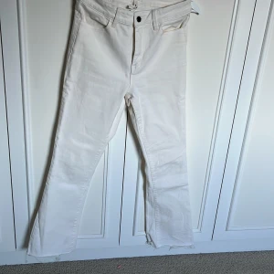 Vita bootcut jeans från Object S - Snygga vita jeans från Object i storlek S. Modellen har bootcut-ben och råa, fransiga benslut för en trendig look. Klassisk femficksdesign och hög midja. Perfekta att styla med sneakers eller boots för en clean vibe.