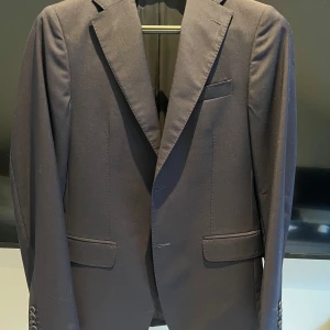 CAVALIERE Kavaj - Snygg mörkblå kavaj från Cavaliere i 100% ull. Klassisk modell med två fickor fram, bröstficka och fyra knappar vid ärmslutet. Perfekt passform och stilren look, passar dig som vill ha en elegant och tidlös stil. 48/48. Ny pris 5 100kr