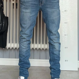 Tiger of Sweden Jeans - Jag säljer ett par blåa tiger of sweden jeans slim i bra skick. Modellen på bilden är cirka 183 lång och passar perfekt.Midjan är i storlek 30. Funkar jättebra nu i till höst. Säljer vidare då de inte passade. (Säljer åt någon annan) 