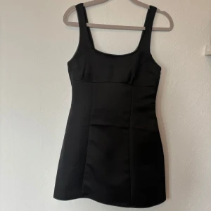 Svart miniklänning  - Klänning med snygg passform vid bröstet och kjolen. Materialet är lite glansigt, nästan som satin. Storlek 36 från hm divided. Jag har endast använd den en gång på min studentskiva så den är väldigt bra skick.  Längd från armhåla till klänningens slut: 55 cm Mått under byst: 37 cm Mått från axelband till klänningens slut: 78 cm  Skriv om du har några frågor☺️