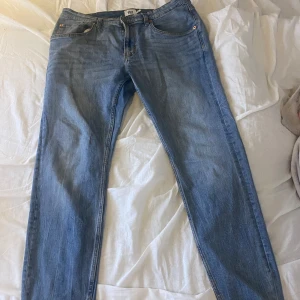 Ljusblå jeansbyxor från 157, XL - Snygga ljusblå jeansbyxor från 157 i storlek XL. Klassisk femficksmodell med raka ben och normal passform. Jeansen har en enkel design utan mönster och är tillverkade i mjukt denimtyg som är skönt att bära. Perfekta för dig som gillar stilrena och bekväma jeans.