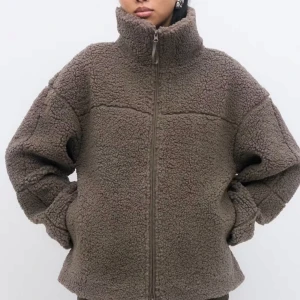 Brun teddyjacka med dragkedja - Mysig brun teddyjacka från Gina tricot. Perfekt för kyliga dagar och enkel att styla till olika outfits. Ordinarie pris 499kr. Storlek M men passar er med storlek L också.