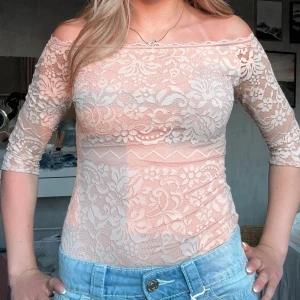 Rosa spetsbody från Intimissimi - Supersöt rosa body från Intimissimi med blommig spets och offshoulder-design. Toppen har trekvartsärm och är figurnära med transparenta spetsdetaljer. Perfekt för dig som gillar romantisk och feminin stil. Storlek S men passar xs! 