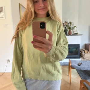 Ljusgrön sweatshirt i bomull - Enkel och chill ljusgrön sweatshirt med rund hals och långa ärmar. Tröjan har ribbade muddar vid ärmslut och nederkant. Perfekt för en avslappnad stil och funkar året runt. Materialet känns mjukt och skönt mot huden.