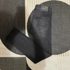 Svarta slim jeans Jack & Jones Glenn - Säljer ett par svarta slim fit jeans från Jack & Jones, modell Glenn. Jeansen har en snygg tvätt med lätt slitning. Inga defekter, pris kan diskuteras👍