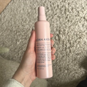 Björn Axén värmeskyddsspray 150ml - Säljer en ljusrosa värmeskyddsspray från Björn Axén som skyddar håret vid styling upp till 220°C. Flaskan rymmer 150 ml och har en smidig sprayfunktion. Perfekt för dig som ofta använder plattång eller locktång och vill skydda håret mot värmeskador. ENDAST använd 2 gånger! Säljer pga doftkänslighet, kan inte använda parfymerade produkter längre