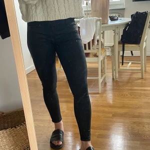 Svarta skinny jeans från Mango - Säljer ett par svarta skinny jeans från Mango. De är högmidjade och sitter tight hela vägen ner till ankeln. Klassisk femficksmodell med knapp och dragkedja framtill. Perfekta om du gillar en clean och slimmad look.