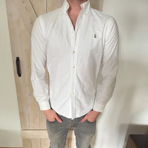 Vit skjorta från Ralph Lauren - Klassisk vit skjorta från Ralph Lauren. Skicket är väldigt bra inga tecken på användning. Modellen på bilden är 179 och väger 76