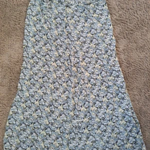 Blommig långkjol från H&M, strl 44 - Supersöt långkjol från H&M i storlek 44 med blommigt mönster i ljusblått, vitt och lite gult. Kjolen är tillverkad i 100% viskos och har en flowy passform som känns riktigt chill och somrig.