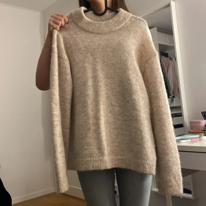Beige stickad tröja med hög krage - Mysig beige stickad tröja i storlek xs men passar S och nästan M. Helt oanvänd. 