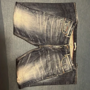 Blå jeans från Tommy Hilfiger - Snygga blå jeans från Tommy Hilfiger med en klassisk straight fit. De har en lätt slitning på framsidan och en läderpatch med logga på baksidan. Perfekta för en avslappnad stil. 32 i längd och bred 