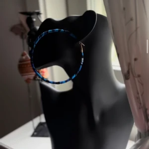 Blå-randiga stora hoop-örhängen - Stora hoop-örhängen med blå och svarta ränder som ger en cool och unik look. Örhängena är lätta och perfekta för att sticka ut. Säljs av Shop with Tyra och passar dig som gillar statement-accessoarer. Följ oss på Instagram; @shop_with_tyra