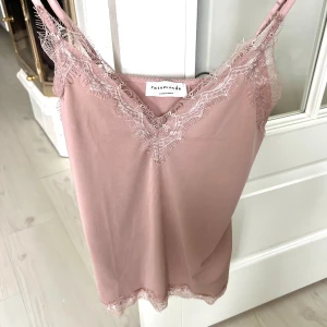 Rosa linnetopp med spets från Rosemunde - Supersött ljusrosa linne från Rosemunde med tunna axelband och v-ringning. Toppen har spetsdetaljer längs urringning och nederkant. Pris kan alltid diskuteras❤️