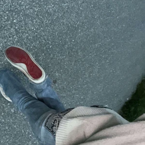 Christian Louboutin sneakers med nitar - Säljer ett par unika sneakers från Christian Louboutin i beige och ljusbrun mocka med ikoniska röda sulor. Skorna har coola silverfärgade nitar på tån och snörning framtill. Perfekta för dig som vill sticka ut med exklusiv streetstyle.