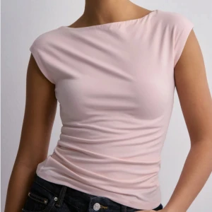 Ljusrosa topp från Nelly - Säljer en ljusrosa, tight topp med bred halsringning från Nelly. Toppen är ärmlös och har en stretchig passform (passar XS-M) som sitter snyggt mot kroppen. Den är slutsåld och går inte att köpa längre🩷Kan gå ned i pris vid snabb affär🩷Hör av er vid frågor!