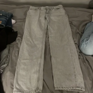 Gråa wide jeans från Perfect Jeans - Säljer ett par ljusgrå jeans från ginatricot i storlek 34. De har en rak och bred passform med klassisk femficksdesign och normal midja. Perfekta för dig som gillar lite mer baggy 