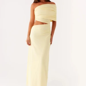 Ljusgul offshoulder långklänning - Supersnygg ljusgul långklänning med offshoulder och asymmetrisk cut-out i midjan. Klänningen har draperad överdel och en axel, vilket ger en trendig och unik look. Perfekt för dig som vill sticka ut med en stilren och modern vibe. Aldrig använd!