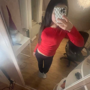 Röd långärmad topp i bomull - Enkel och snygg röd långärmad topp med rund halsringning. Modellen är figurnära och passar perfekt till jeans eller kjol. Tillverkad i mjuk bomull som känns skön mot huden. Perfekt för dig som gillar en clean och stilren look.