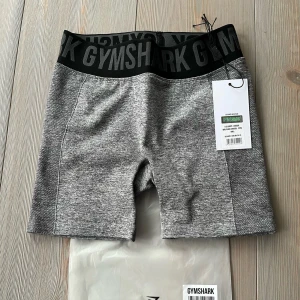 Grå Gymshark shorts  - Så snygga gymshorts från gymshark! I mkt bra skick men används aldrig 🩷vet inte storlek men gissar på S, passar fler storlekar då de är stretchiga
