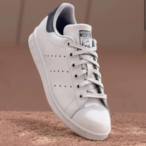 Adidas Stan Smiths  - Säljer ett par adidas stan smiths med marinblå kant!! Har en liten defekt nära sulan där färgen suddats lite pch skosnören spm blivit lite mörkare med tid, men knappast något som märks🤗 Hör av dig vid funderingar eller prisförslag❣️