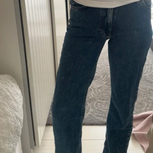 Blå mid wide jeans från Bik bok  - Säljer ett par klassiska blå jeans från Bik Bok  Denim i modellen mid wide. Jeansen har raka ben och är mid waist. Tillverkade i jeansmaterial med fem fickor och snygga kortast sömmar. 