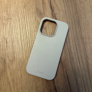 Beige skal Holdit  - Säljer ett beige skal från Holdit för iPhone 14 pro, i fint skick! Finns två små märken på, se bild, men inget som stör 
