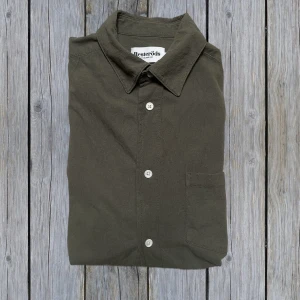 Olivgrön skjorta från Resteröds - Stilren olivgrön/mörkgrön skjorta från Resteröds med klassisk krage, bröstficka och knäppning framtill. Skjortan är i storlek S och i väldigt fint skick utan defekter. Köpt för ca 500kr | tveka inte att höra av vid funderingar!