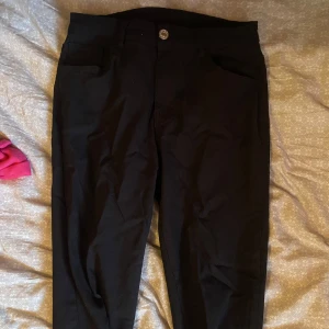 Svarta chinos med raka ben - Snygga svarta chinos med klassisk passform och raka ben. Byxorna har fickor fram och bälteshällor i midjan. Perfekta för en clean och stilren look, funkar till det mesta i garderoben.