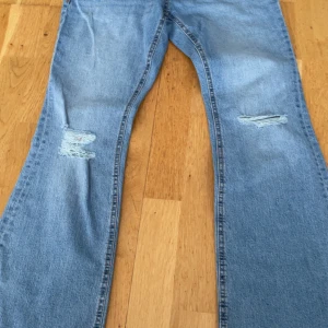 Ultra low bootcut jeans med slitningar - Snygga ljusblå jeans från Perfect Jeans i modell ultra low med bootcut och slitna detaljer på knäna. Aldrig använt ❤️