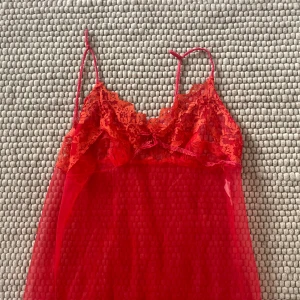 Vintage nattlinne - Suuperfint långt vintage nattlinne. Transparent röd med orange spets, uppskattar att den passar storlek M. Perfekt för layering ❤️Köpt på beyond retro 🫶🏻 Lite sliten vid spetspartierna 🫶🏻