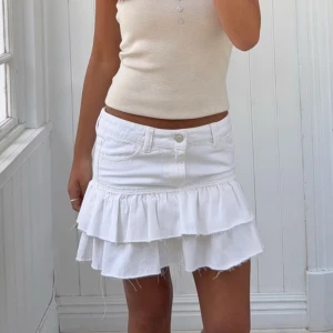 Vit volangkjol - Jättesnygg vit jeanskjol med volanger från Gina Tricot i strl 152. Helt ny med lappar kvar.