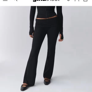 Svarta yoga pants - Snygga svarta yoga pants från Gina Tricot med låg midja. Byxorna har en tight passform upptill och utsvängda ben, vilket ger en trendig siluett. Perfekta att styla med crop tops eller hoodies för en cool vardagslook.