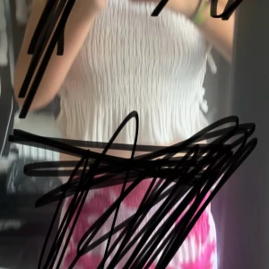 Vit smockad ärmlös topp - Supersöt vit smockad topp med ganska lösoch tunna axelband. Toppen är kort ärmadoch har en stretchig struktur som ger en snygg och bekväm look. Perfekt till sommaren och lätt att matcha med olika stilar.