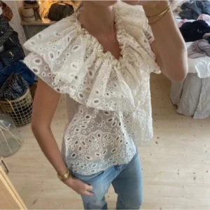 Broderad blus med volang Wera - Supersnygg blus från Wera med stora volanger runt halsen och broderade hålmönster över hela toppen. Säljer i svart, nypris 700💕