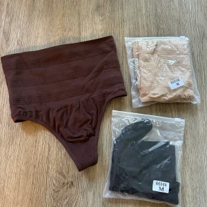 Trepack shapingtrosa med hög midja - Säljer trepack shapingtrosa med hög midja och diskret randigt mönster. Trosan är tillverkad i stretchigt syntetmaterial som formar och ger stöd. Perfekt för dig som vill ha en smickrande siluett under kläderna. Färgerna brun, beige och svart. Aldrig provade. Helt nya 