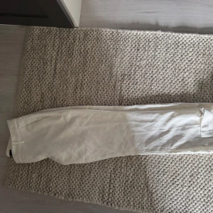 Vita lågmidjade kostymbyxor med slits från BikBok - Snygga vita, lågmidjade, kostymbyxor med slits  från BikBok. De är modellen Vera och storlek 38. Byxorna är endast testade och har därför inga defekter!!💞