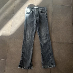 Grå bootcut jeans från Zara 164 - Snygga grå jeans från Zara i bootcut-modell med slits nertill på benen. Jeansen har klassisk femficksdesign och är tillverkade i mjukt denimtyg. Perfekta för dig som gillar en avslappnad men trendig look.❤️