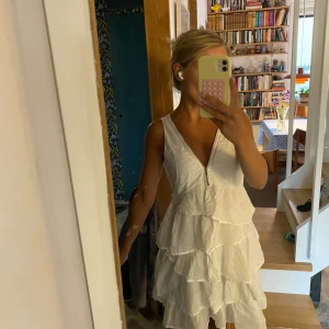 Vit volangklänning med dragkedja - Supersöt vit kortklänning. Cool och unik! Dragkedjan drar man upp o ner som man vill.💞🌸🪩