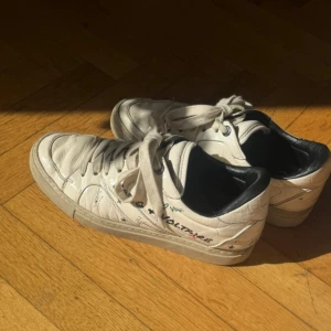 Vit sneakers Zadig & Voltaire - Snygga cremevita sneakers från Zadig & Voltaire med coola tryck. Skorna har snörning, platt sula och är gjorda i skinn. Perfekta för dig som gillar en unik och trendig look.