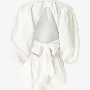 Vit blus med öppen rygg och rosett - Superfin vit blus med puffiga trekvartsärmar och öppen rygg som knyts med en stor rosett. Blusen har rund halsringning och är gjord i ett lätt bomullstyg.