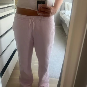 Ljusrosa mjukisbyxor  - Säljer ett par ljusrosa mjukisbyxor från Gina med resår i midjan och snörning framtill. Byxorna har raka ben och sidofickor, perfekta för chill dagar. Mjukt material som känns skönt mot huden. Säljer även tillhörande hoodie så kolla in den i tidigare annons!🤍