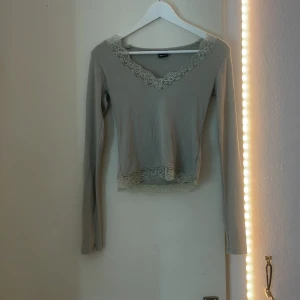 Ljus/grön/gråaktig tröja från Gina tricot i storlek xs - Oanvänd ribbad tröja från Gina tricot i storlek xs med spets detaljer. Tröjan har inga skador och har en tajt passform samt att den e stretchig och oanvänd, säljer för de blev ett köp som inte används🤍.